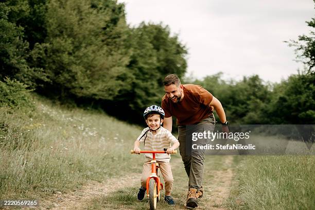 le père enseigne à son fils à faire du vélo - grands évènements de la vie photos et images de collection