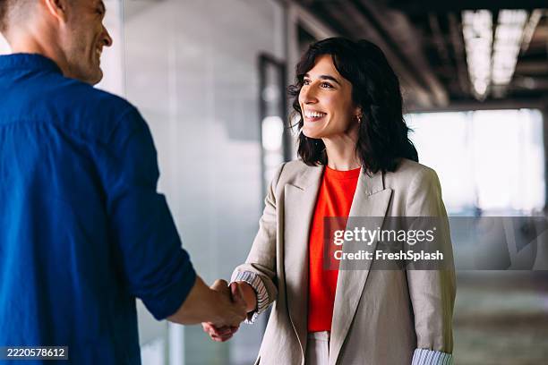 erfolgreicher business-handschlag zwischen selbstbewussten profis in modernen büroräumen - zuverlässigkeit stock-fotos und bilder