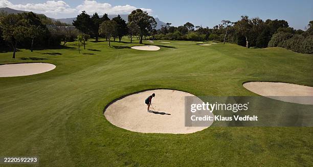 woman playing golf in sand trap - locais geográficos imagens e fotografias de stock