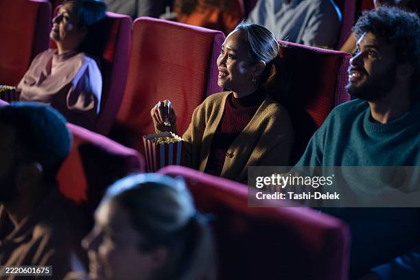 gruppe von freunden, die einen film in einem kino genießen - filmfestival stock-fotos und bilder
