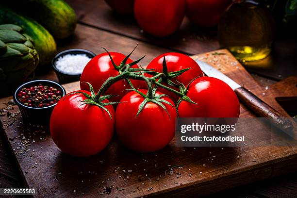 tomates ecológicos maduros en una tabla de cortar de madera, comida mediterránea sana y jugosa, verdura roja recién recogida lista para comer, comida para cocinar o hacer dieta, comida ecológica - tomate fotografías e imágenes de stock