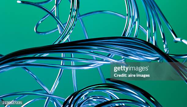 metallic wires creating an abstract design on a green background - fil de fer photos et images de collection