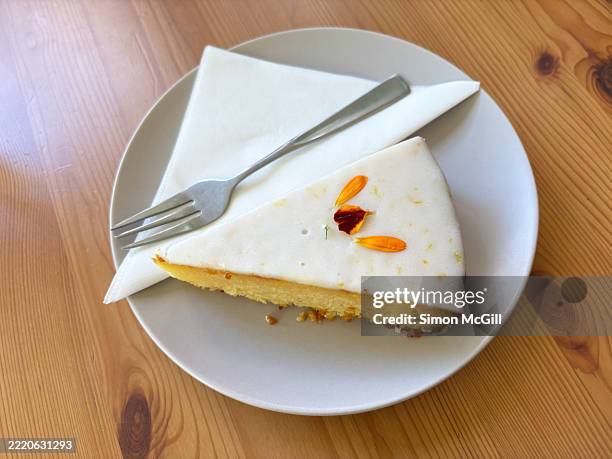 slice of lemon drizzle cake on a plate - lemon cake slice stock pictures, royalty-free photos & images