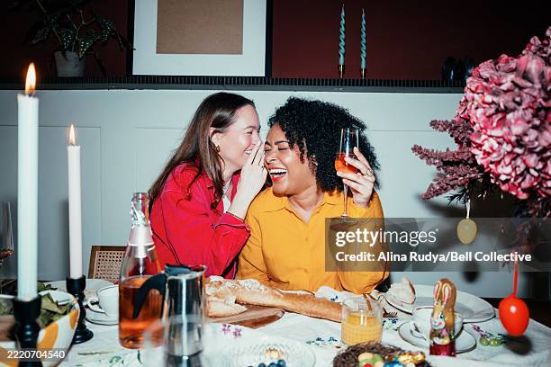 two women sharing a gossip at the holiday dinner - cotilleo fotografías e imágenes de stock
