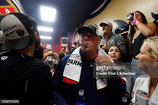 Matthew Tkachuk of the Florida Panthers father Keith Tkachuk celebrates with a cigar in the locker room after their win over the Edmonton Oilers in...