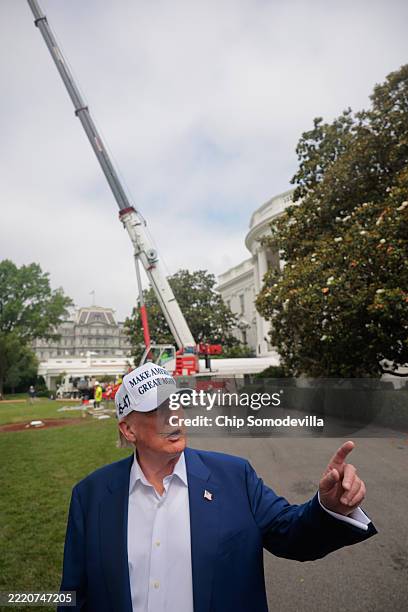 President Donald Trump talks to reporters as workers install a new flag pole on the South Lawn of the White House on June 18, 2025 in Washington, DC....