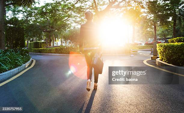 mujer de negocios caminando por la acera - calle bifurcada fotografías e imágenes de stock