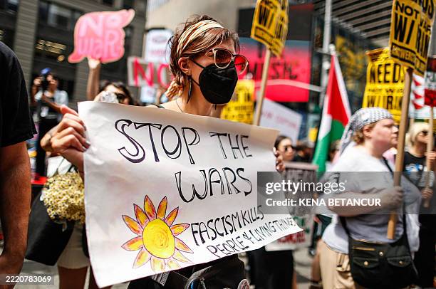 People take part in an anti-war demonstration at Times Square in New York on June 22 protesting US strikes on Iranian nuclear sites. The surprise US...