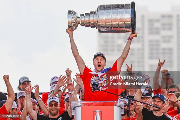 Florida Panthers goaltender Sergei Bobrovsky hoists the Stanley Cup as teammates celebrate on stage during the team's victory parade and rally along...