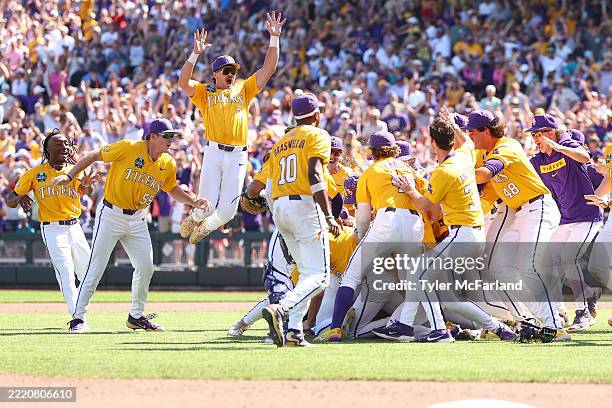 Jake Brown of the LSU Tigers leaps onto the dogpile in celebration after defeating the Coastal Carolina Chanticleers in game two of the Division I...