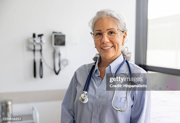 happy female doctor in her consultation room and smiling - kvinnlig läkare bildbanksfoton och bilder