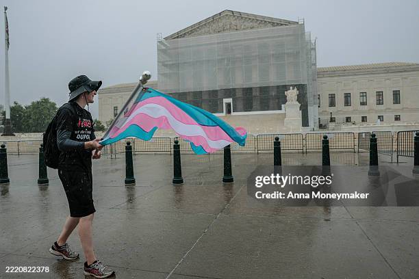 Protester waves a transgender pride flag outside of the U.S. Supreme Court Building on June 18, 2025 in Washington, DC. Advocates organized a rally...