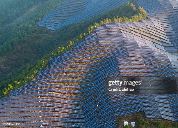 solar panels on mountain slope - emissioni di co2 foto e immagini stock