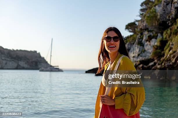 young woman smiling at the beach in menorca, balearic islands, spain - menorca stockfoto's en -beelden