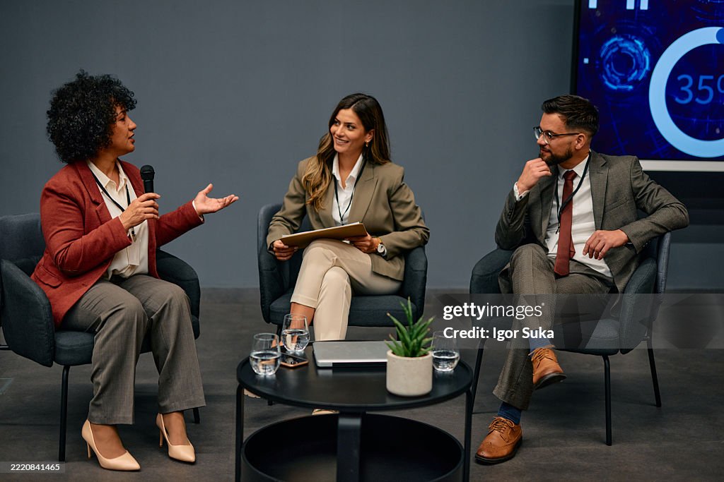 Geschäftsleute diskutieren während einer Podiumsdiskussion