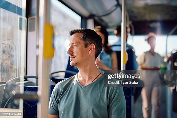 pensive man looking out the window while traveling by bus - public transport stock pictures, royalty-free photos & images