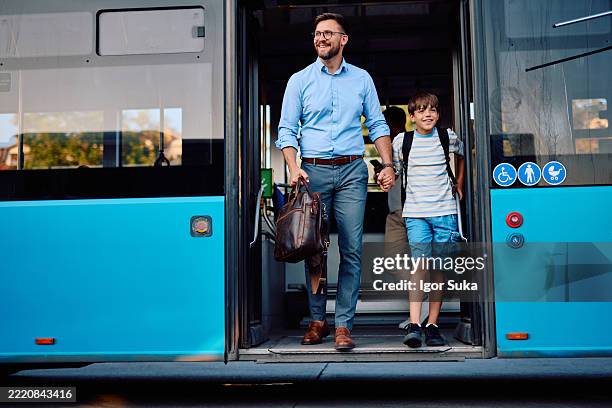father and son exiting the bus holding hands - bus-door stock pictures, royalty-free photos & images