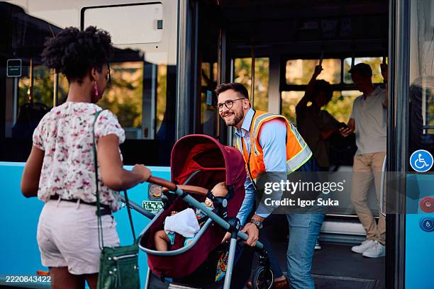 bus driver helping young mother boarding a bus with a stroller - kindness stock pictures, royalty-free photos & images