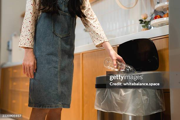 mother teaching her daughter how to sort trash for recycling and proper disposal - biodegradable stock pictures, royalty-free photos & images