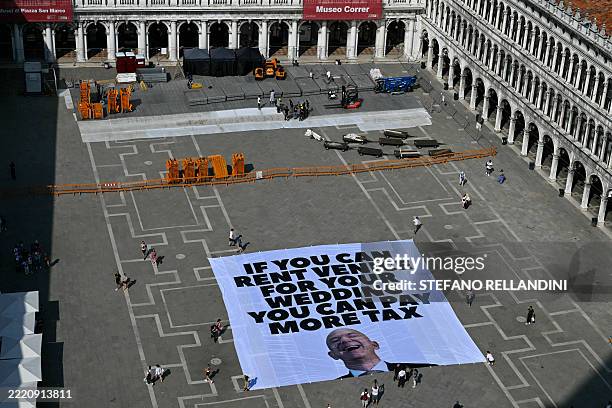 Activists of international environmental group Greenpeace deploy a giant banner displaying a picture of Jeff Bezos and reading "If you can rent...