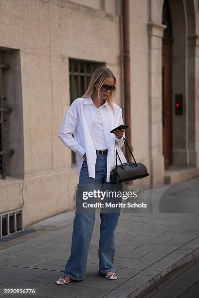 Mirja Klein is seen wearing a white open oversized white button-down boxy shirt with pointed collar and dropped shoulders from MY ESSENTIAL WARDROBE;...