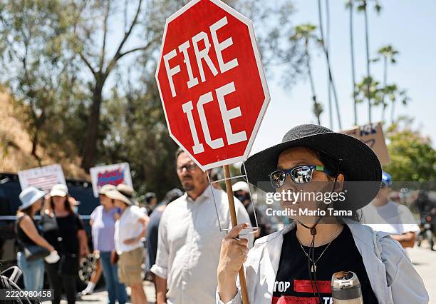 Protesters demonstrate not far from federal agents staged outside a gate of Dodger Stadium on June 19, 2025 in Los Angeles, California. The Los...