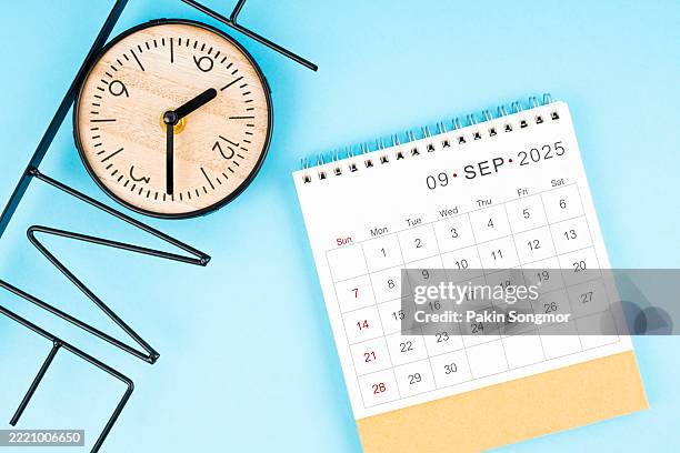september desk calendar for 2025 year with clock on blue color background, flat lay. - september stock pictures, royalty-free photos & images