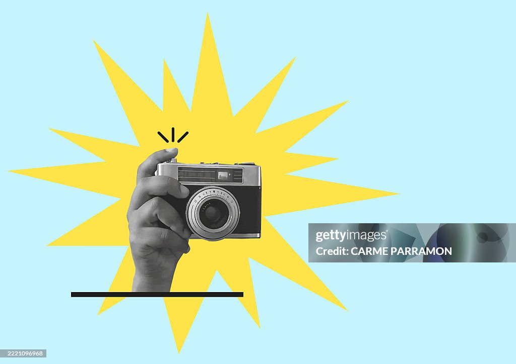 A hand with an old analog camera