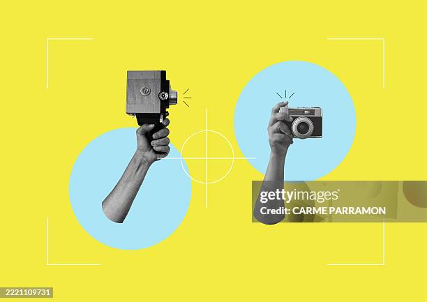 stockillustraties, clipart, cartoons en iconen met two hands with an old recording analog cameras. - filmen