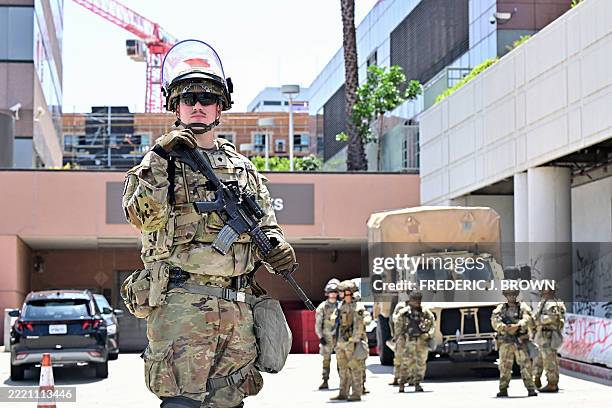Armed members of the National Guard are seen outside the Edward Roybal Federal Building, with graffiti visible after recent protests against...