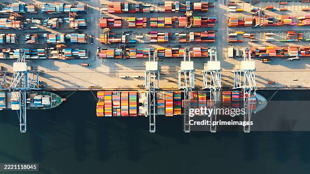logistica di carico e scarico del terminal merci globale dal punto di vista aereo operazioni portuali con gru e navi merci attraccate - darsena foto e immagini stock