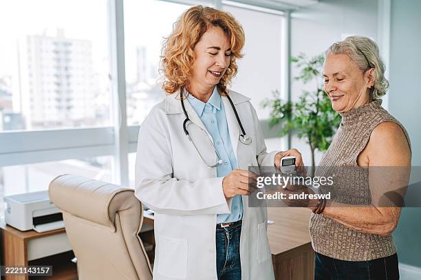 médico que mide la diabetes de un paciente mayor - atención primaria fotografías e imágenes de stock
