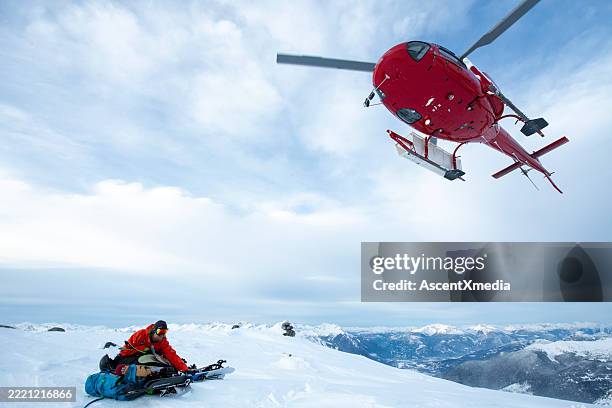 helicopter picks up backcountry skier from mountain - rescue stock pictures, royalty-free photos & images