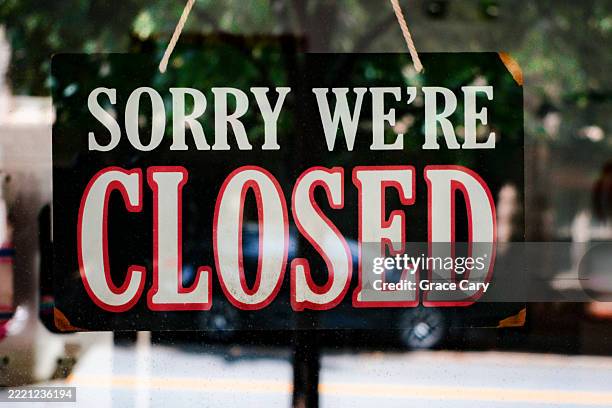 "sorry we're closed" sign hangs from store's door - señal de cerrado fotografías e imágenes de stock