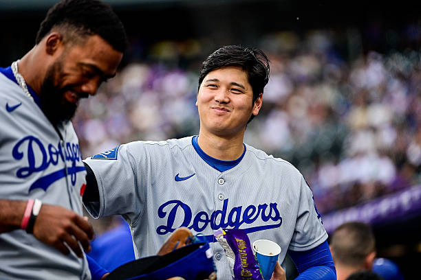 Los Angeles Dodgers designated hitter Shohei Ohtani welcomes a teammate to the dugout after a defensive half inning during a game between the Los...