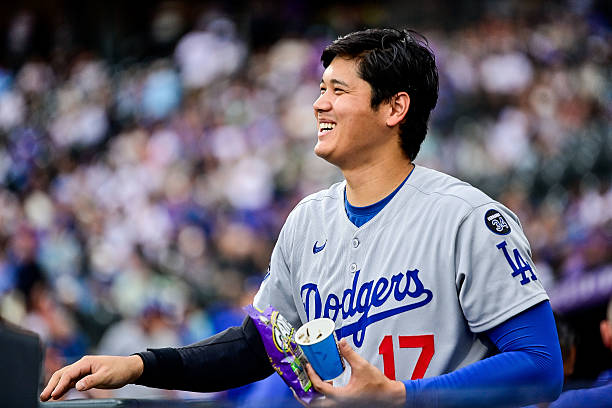 Los Angeles Dodgers designated hitter Shohei Ohtani welcomes a teammate to the dugout after a defensive half inning during a game between the Los...