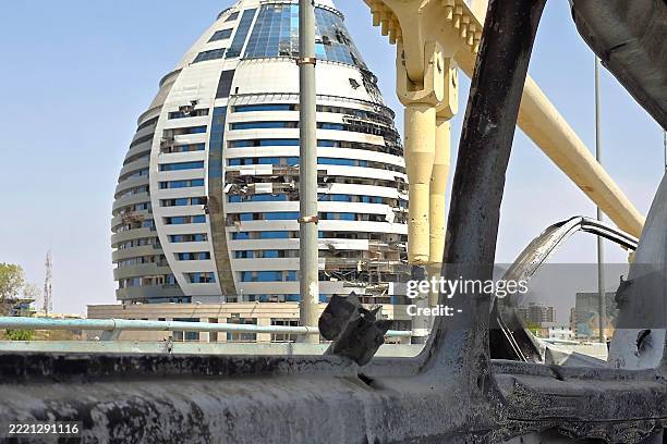 This picture taken through the shattered window of a damaged car shows the damaged Corinthia Hotel tower building in Sudan's capital Khartoum on June...