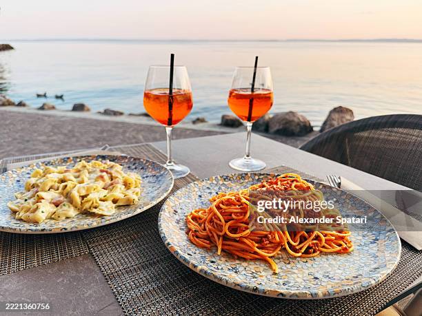 spaghetti and spritz served at a restaurant by waterfront at lake garda, veneto, italy - user generated content stock pictures, royalty-free photos & images