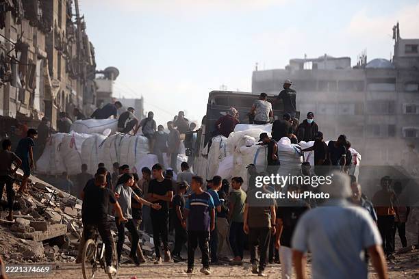 Security guards stand atop trucks carrying humanitarian aid coming in from the Zikim border crossing along al-Rashid Street in western Jabalia,...