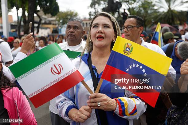Woman carrying an Iranian flag and a Venezuelan flag participates in a march for peace, disarmament, and respect for international law in Caracas on...