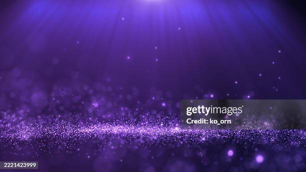 Glitter light electric purple particles stage and light shine abstract background. Flickering particles with bokeh effect.