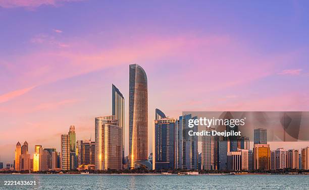 abu dhabi city skyline at sunset, united arab emirates - abu dhabi stock pictures, royalty-free photos & images