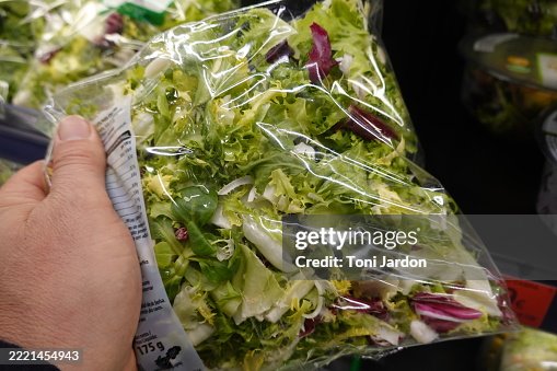 Customer choosing fresh bagged salad in supermarket Customer choosing fresh bagged salad in supermarket