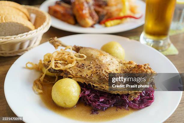 roast duck leg with potato dumplings and red cabbage - rotkohl stock-fotos und bilder