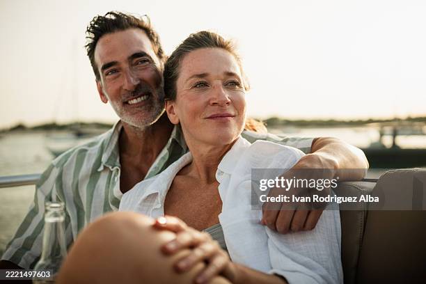 pareja madura feliz abrazándose en un barco al atardecer - 40 49 años fotografías e imágenes de stock