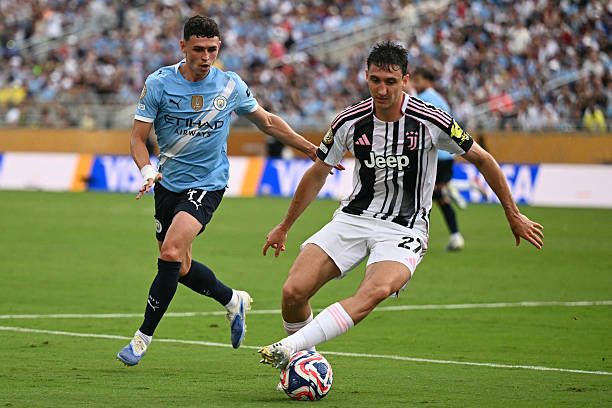 Juventus' Italian defender Andrea Cambiaso controls the ball past Manchester City's English midfielder Phil Foden during the FIFA Club World Cup 2025...
