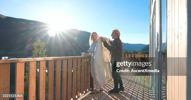 mature couple enjoy hot beverage on deck at sunrise - early retirement stock pictures, royalty-free photos & images