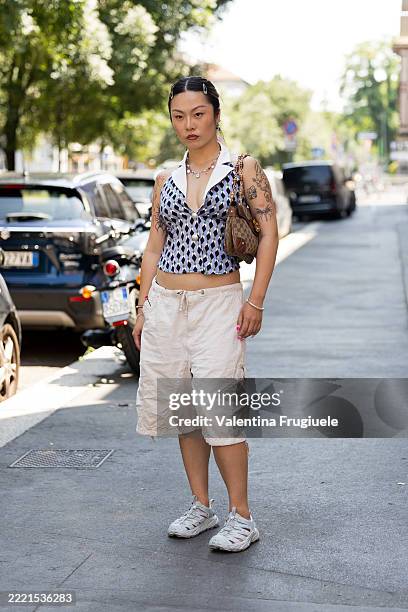 Guest wears a geometric print halter top with a white spread collar and plunging neckline, paired with voluminous drawstring-hem beige cargo shorts,...