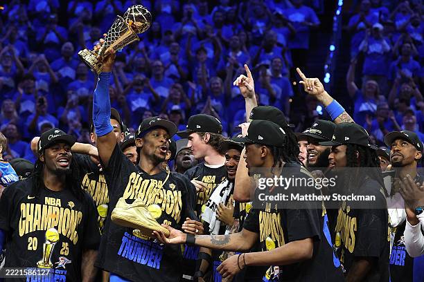 Shai Gilgeous-Alexander of the Oklahoma City Thunder celebrates with the Bill Russell NBA Finals Most Valuable Player trophy with his new one-of-one...