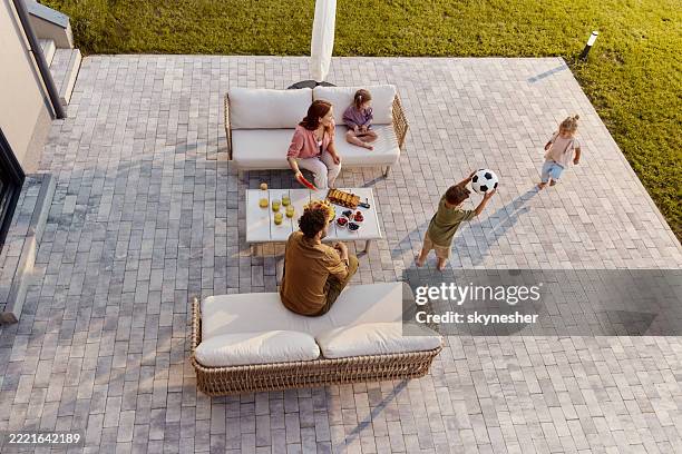 above view of happy family having fun on a patio in the backyard. - patio stock pictures, royalty-free photos & images